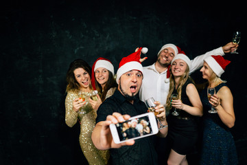 Christmas celebration, friendship, winter holidays. Happy people drinking champagne taking selfie on New Year party.