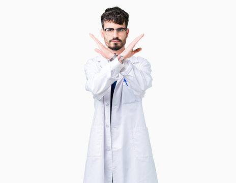 Young professional scientist man wearing white coat over isolated background Rejection expression crossing arms doing negative sign, angry face