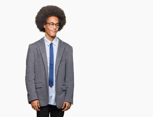 Young african american business man with afro hair wearing glasses looking away to side with smile on face, natural expression. Laughing confident.