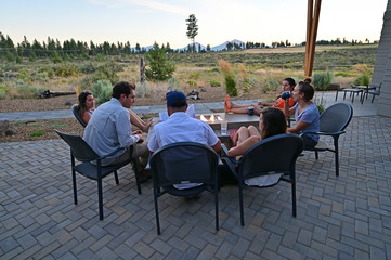 Six friends around a fire pit enjoy afternoon view of landscape around Sisters, Oregon on a perfect summer afternoon.