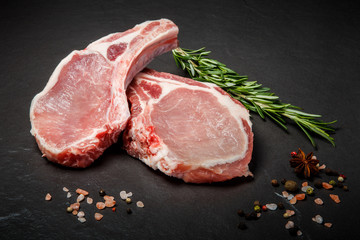 two pieces of raw ribs with meat served with green rosemary