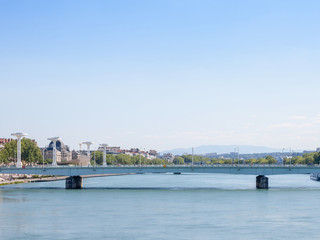 Pont de la Guillotiere bridge in Lyon, France over a panorama of the riverbank of the Rhone river (Quais de Rhone) with older buildings and landmarks in background