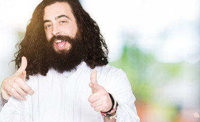 Man wearing Jesus Christ costume pointing fingers to camera with happy and funny face. Good energy...