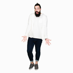 Fototapeta premium Young man with long hair and beard wearing sporty sweatshirt making fish face with lips, crazy and comical gesture. Funny expression.