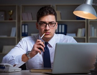 Businessman under stress smoking in office