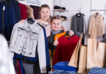 Adult woman with daughter holding many bags