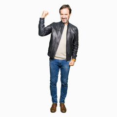Middle age handsome man wearing black leather jacket Strong person showing arm muscle, confident and proud of power