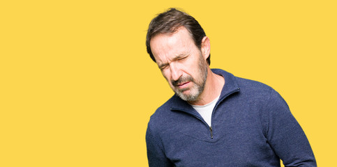 Fototapeta premium Middle age handsome man wearing a sweater with hand on stomach because nausea, painful disease feeling unwell. Ache concept.