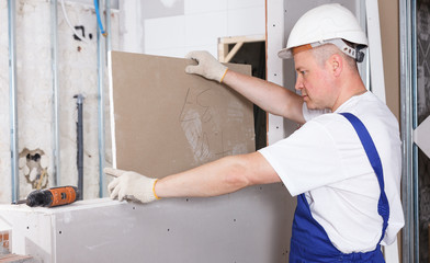 Contractor installing drywall construction