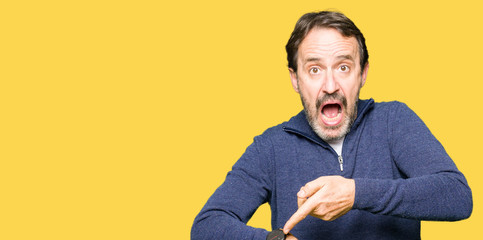 Middle age handsome man wearing a sweater In hurry pointing to watch time, impatience, upset and...