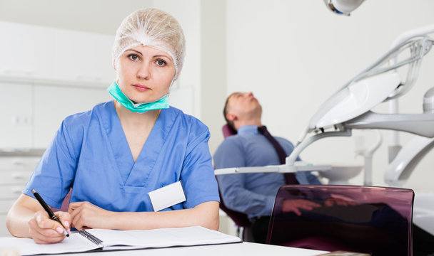 Concentrated female dentist at table