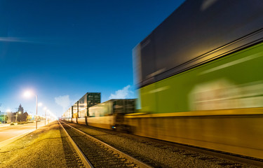 Night train locomotive in motion on railroad at night.