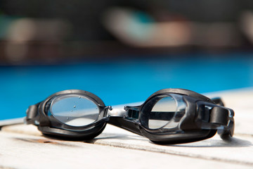 swimming goggles  on the deck beside the pool