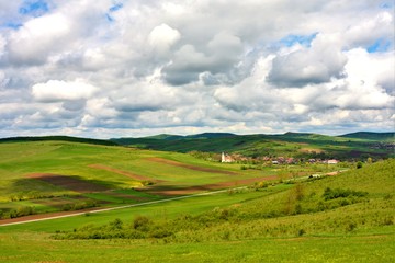 Fototapeta na wymiar landscape with a village between hills in Romania