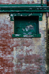 Fototapeta na wymiar Peeling Brick Wall with Boarded WIndow
