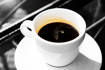 Double espresso in cup on glass table