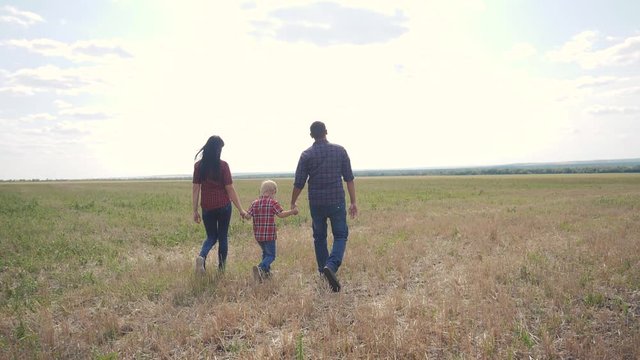 happy family teamwork friendship care concept slow motion video. father mom and son walk in nature sunset lifestyle sunlight hold hand. happy family parents man and girl hold little boy walking hand