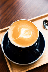Hot latte coffee serve in dark blue cup with love latte art