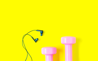 Fitness and healthy active lifestyle background concept, Equipment for gym and home pink dumbbell with black earphone on yellow color background.