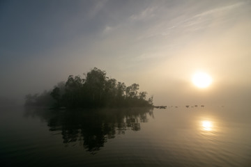 Fototapeta na wymiar small island on a lake in mist, sympathy message 