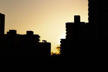 Fototapeta premium Sun setting behind buildings in Ribeirão Preto