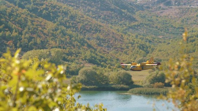 yellow Fire fighting plane before landing on lake in croatia