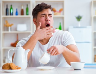 Man falling asleep during his breakfast after overtime work