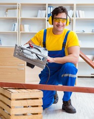 Repairman carpenter cutting sawing a wooden plank with a circula