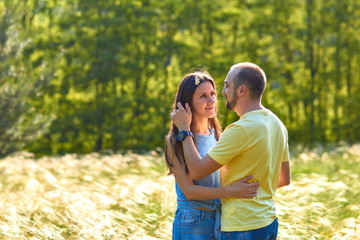 Fototapeta premium Lovers. A young couple. The guy with the girl are walking in the forest. Loving couple hugs sensually. Lovers man and woman in the arms of each other. Romantic walk in the forest. Loving relationship