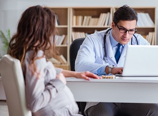 Fototapeta premium Pregnant woman visiting doctor for consultation