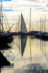 Fototapeta na wymiar Sailing boat in the port in the sunset sun light