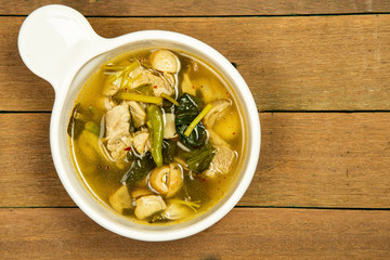 Delicious spicy pork ribs with mushroom soup on white bowl with wooden table background.