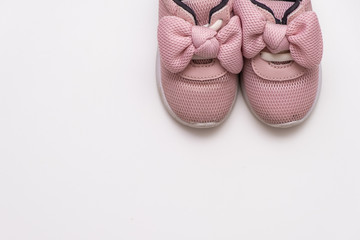 On a white background, pink baby sneakers, copy space