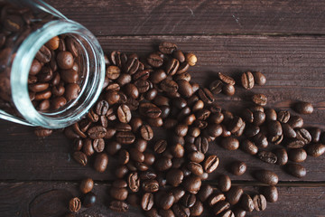 Coffee beans in a glass jar on a dark wooden background