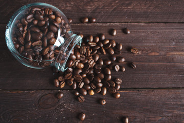 Coffee beans in a glass jar on a dark wooden background