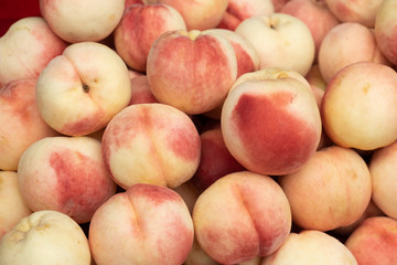 A pile of bright red peach collected from the tree Prepare to be released for sale to customers. That are healthy and eaten. fruit background.