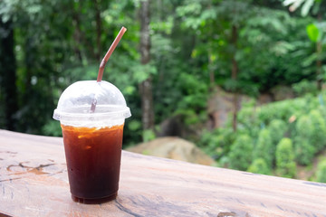 A cup of iced tea or iced coffee on a wooden table, refreshing and tranquil. Suitable for relaxing on holidays. for copy space background.