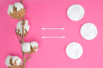 Cotton branch, pads and sticks equal sign shape on bright pink background. Cosmetology, production, healthcare concept. Flat lay, top view, mock up, copy space, layout design