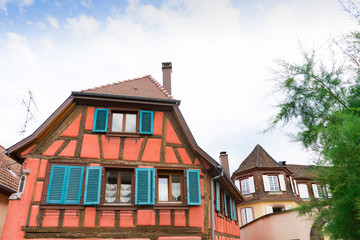Orange half timbered house with blue shutters  in Ribeauville, France