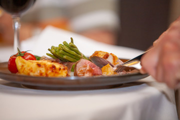A person eating a high class dinner meal in a restaurant setting