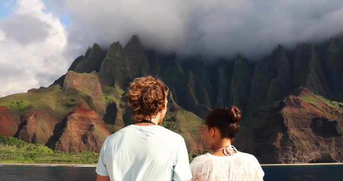 Cruise ship boat tourists People on Na Pali Coast of Kauai, Hawaii. Sunset cruise leisure tourist activity in NaPali. Couple looking at Famous Hawaiian travel destination. Hawaii, the Honopu arch