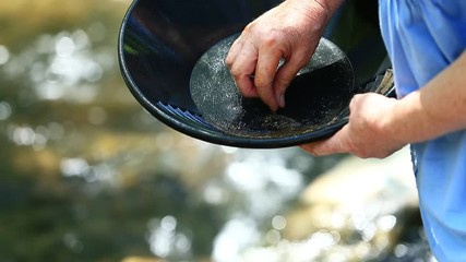 Close Up Sifting through Gold Pan on River - Shallow Depth of Field.