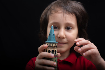 Little boy holding model of the Galata Tower in Turkey