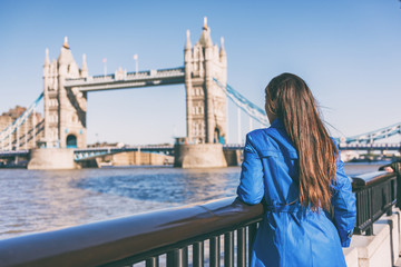 London travel woman looking at Tower Bridge. Urban lifestyle tourism Europe tourist city destination vacation person enjoying view of famous attraction, England, Great Britain, UK.