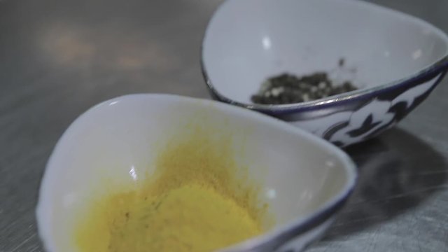 Spices in small bowls, pepper, turmeric, zira, the camera moves diagonally