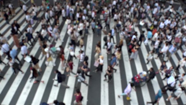 UMEDA, OSAKA, JAPAN - CIRCA JULY 2019 : Aerial blurred view of zebra crossing near Osaka train station. Crowd of people at the street. Shot in busy rush hour. Slow motion.