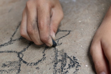 kid drawing with charcoal