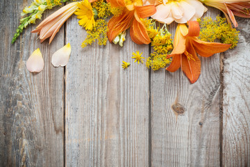 Fototapeta premium yellow and orange flowers on old wooden background