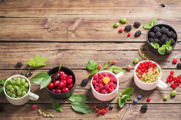 different berries on old wooden background