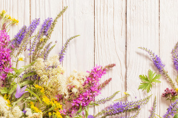 Naklejka premium wildflowers on white wooden background
